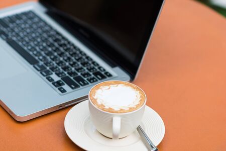 laptop and coffee outdoors in cafeの写真素材