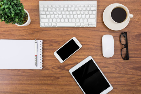 Business desk with a keyboard, mouse and pen on wooden tableの写真素材