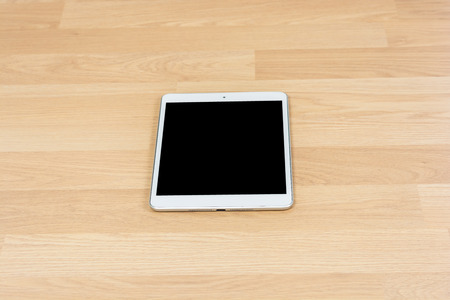 White digital tablet on wooden table backgroundの写真素材