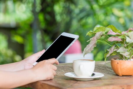 Close up of hands woman using tablet in cafeの写真素材