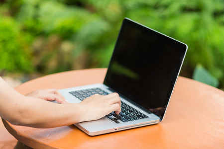 Woman hands typing on laptop outdoors in cafeの写真素材
