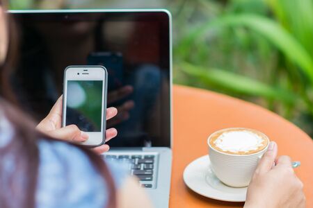 Woman hands typing on laptop outdoors in cafeの写真素材