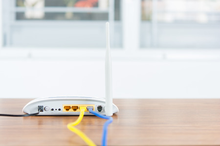 Wireless modem router network hub with cable connect on wooden table in the roomの写真素材