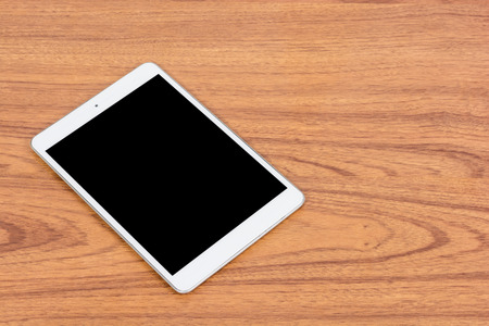 White digital tablet on wooden table backgroundの写真素材