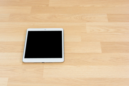 White digital tablet on wooden table backgroundの写真素材