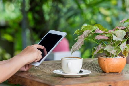 Close up of hands woman using tablet in cafeの写真素材