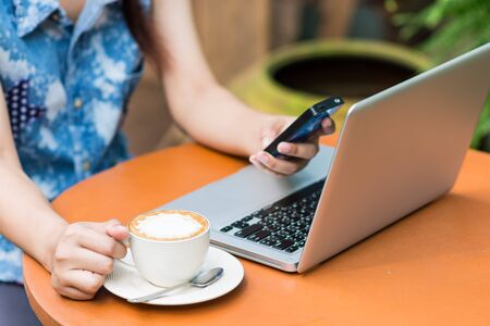 Woman hands typing on laptop outdoors in cafeの写真素材