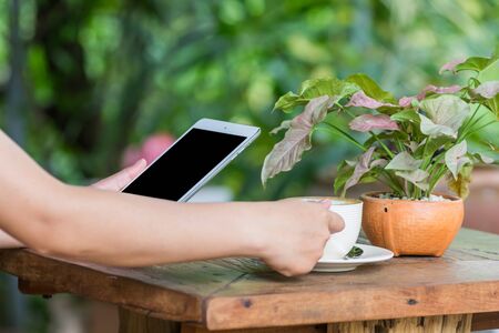 Close up of hands woman using tablet in cafeの写真素材