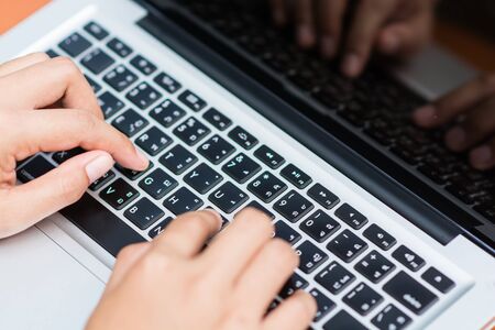 Woman hands typing on laptop outdoors in cafeの写真素材