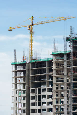 Building crane, engineering and building skyscraper under constructionの写真素材
