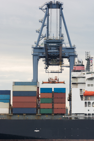 Industrial Container Cargo freight ship with working crane bridgeの写真素材