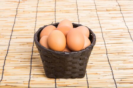Egg collection in the basket on wooden backgroundの写真素材