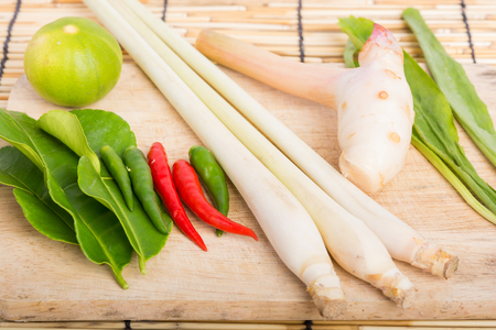 Thai Tom Yam soup herbs and spices, lemongrass, Kaffir Lime leaves, Galangal, Lemon and Chilli on wooden backgroundの写真素材