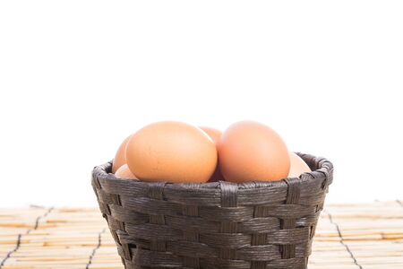 Egg collection in the basket on wooden backgroundの写真素材