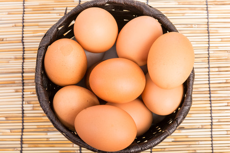 Egg collection in the basket on wooden backgroundの写真素材