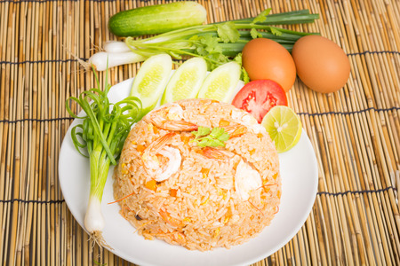 Special shrimp fried rice on white dish on wooden backgroundの写真素材