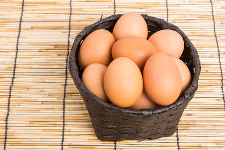 Egg collection in the basket on wooden backgroundの写真素材