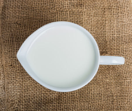 Cow milk and ceramic jug on wooden tableの写真素材