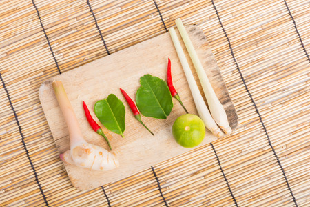 Thai Tom Yam soup herbs and spices, lemongrass, Kaffir Lime leaves, Galangal, Lemon and Chilli on wooden backgroundの写真素材