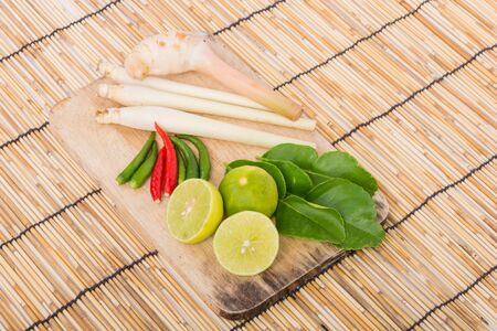 Thai Tom Yam soup herbs and spices, lemongrass, Kaffir Lime leaves, Galangal, Lemon and Chilli on wooden backgroundの写真素材