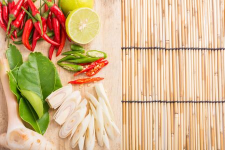 Thai Tom Yam soup herbs and spices, lemongrass, Kaffir Lime leaves, Galangal, Lemon and Chilli on wooden backgroundの写真素材