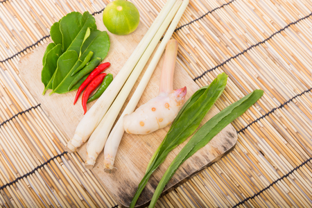 Thai Tom Yam soup herbs and spices, lemongrass, Kaffir Lime leaves, Galangal, Lemon and Chilli on wooden backgroundの写真素材