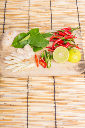 Thai Tom Yam soup herbs and spices, lemongrass, Kaffir Lime leaves, Galangal, Lemon and Chilli on wooden backgroundの写真素材