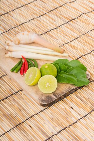 Thai Tom Yam soup herbs and spices, lemongrass, Kaffir Lime leaves, Galangal, Lemon and Chilli on wooden backgroundの写真素材