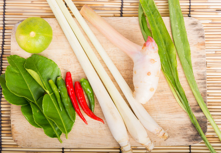 Thai Tom Yam soup herbs and spices, lemongrass, Kaffir Lime leaves, Galangal, Lemon and Chilli on wooden backgroundの写真素材