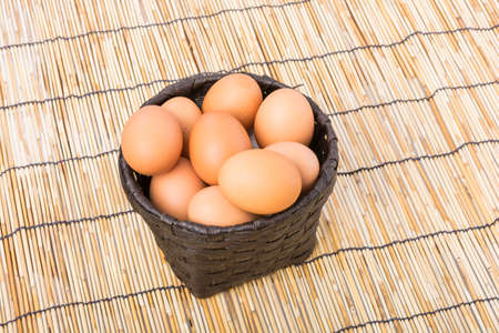 Egg collection in the basket on wooden backgroundの写真素材