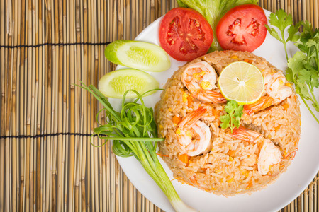 Special shrimp fried rice on white dish on wooden backgroundの写真素材
