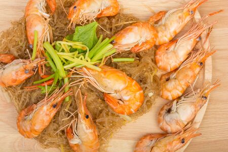 baked vermicelli with shrimp in wood dish on wooden backgroundの写真素材