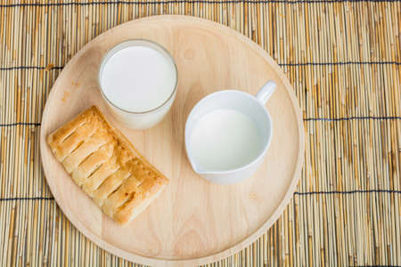 Breakfast pitcher of milk and bread on wooden tableの写真素材