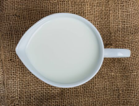 Cow milk and ceramic jug on wooden tableの写真素材