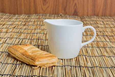 Breakfast pitcher of milk and bread on wooden tableの写真素材