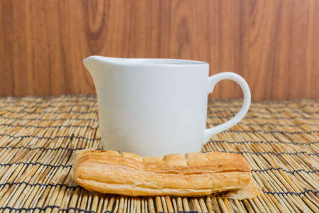 Breakfast pitcher of milk and bread on wooden tableの写真素材