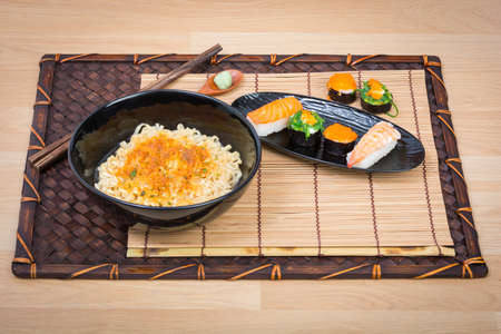 sushi and noodle in black dish on wooden backgroundの写真素材
