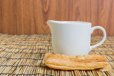 Breakfast pitcher of milk and bread on wooden tableの写真素材