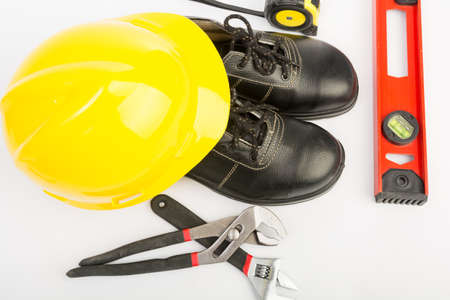 Yellow hard hat and tools on white backgroundの写真素材