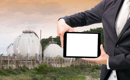 Engineering working hold tablet in front of oil refinery power station