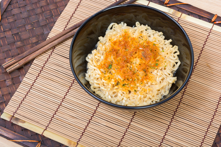 Instant noodles in black cup on wooden table backgroundの写真素材