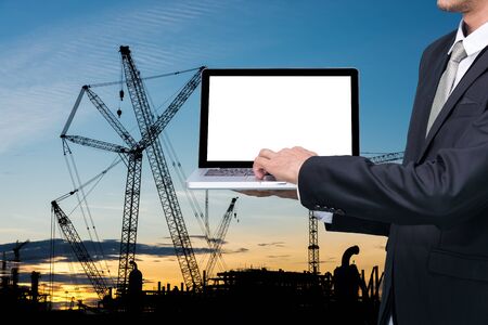 Engineering working hold conputer notebook in front of construction supervisor siteの写真素材