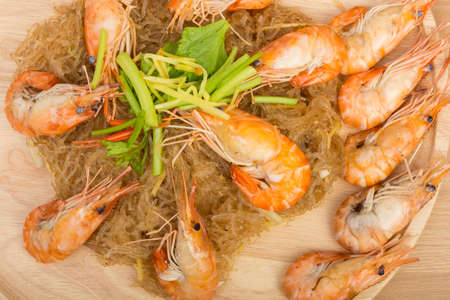 baked vermicelli with shrimp in wood dish on wooden backgroundの写真素材