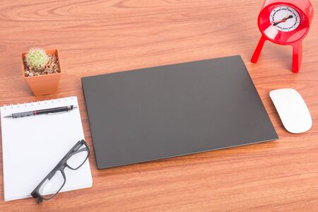 Notebook with close blank screen on wooden tableの写真素材