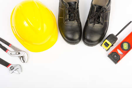 Yellow hard hat and tools on white backgroundの写真素材