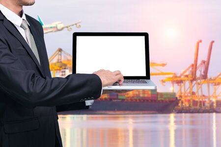 Engineering working hold conputer notebook in front of industrial harbor cargoの写真素材