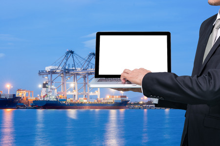 Engineering working hold conputer notebook in front of industrial harbor cargoの写真素材