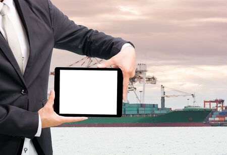 Engineering working hold tablet in front of cargo loading workplaceの写真素材