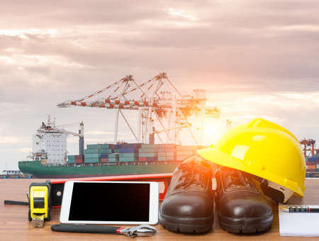 Working table engineer with tablet and tools in cargo port with craneの写真素材