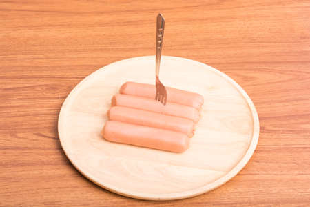 Heap sausages with dish wood on wooden tableの写真素材